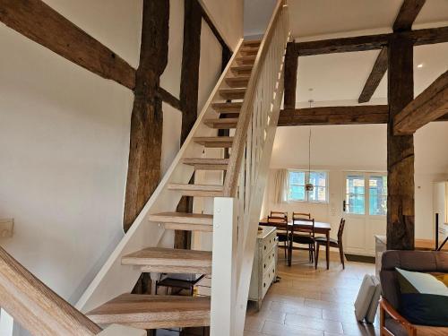 a wooden staircase in a room with a dining room at Haus-Ruhe-unter-Reet in Schmiedendorf