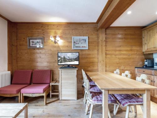 - une cuisine avec des murs en bois, une table et des chaises dans l'établissement Charmant appartement 2 pièces avec mezzanine, balcon et wifi à Val-d'Isère – Animaux acceptés - FR-1-694-200, à Val dʼIsère