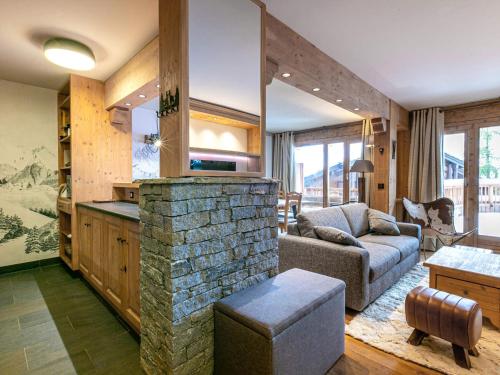 - un salon avec une cheminée en pierre et un canapé dans l'établissement Appartement haut de gamme avec terrasse et accès skis aux pieds à Val-d'Isère - FR-1-694-206, à Val dʼIsère