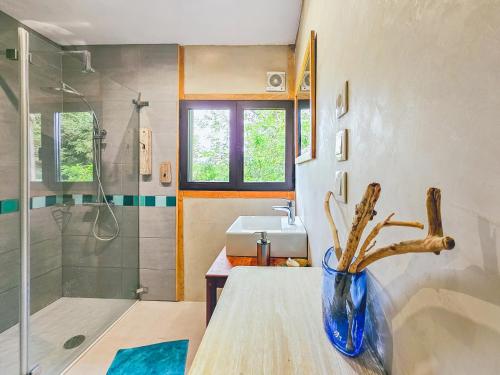 a bathroom with a sink and a vase with a plant at Gîte Au Jardin in Meilhan-sur-Garonne