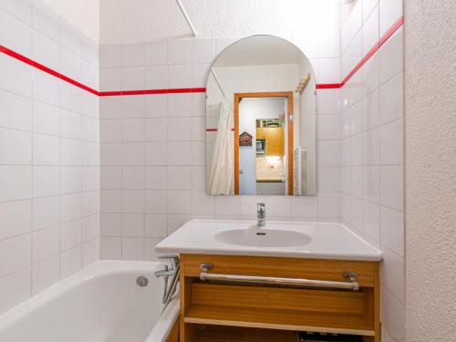 a bathroom with a sink and a tub and a mirror at Appartement Val-d'Isère, 2 pièces, 4 personnes - FR-1-694-249 in Val-d'Isère