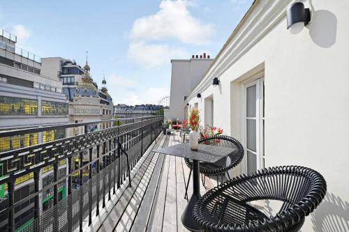 un balcon avec deux chaises et une table sur un immeuble dans l'établissement Exceptional apartment - 4BR-10P - Opéra, à Paris