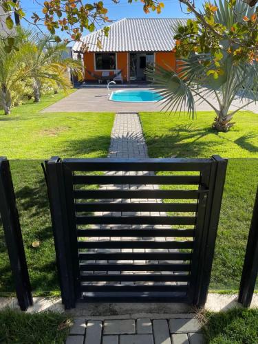 a black metal bench in front of a house at Faith Home 2 in Arraial do Cabo