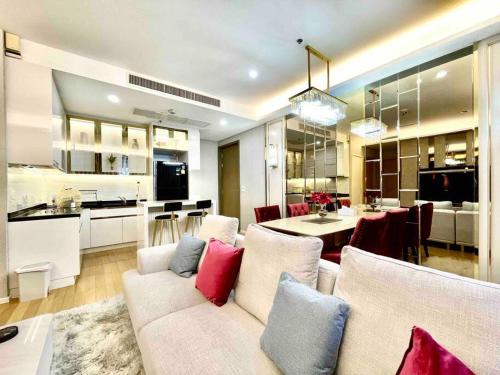 a living room and kitchen with a couch and a table at 2BedRoom-BestLocationBangkok-Emquartier-Metro-PhromPhong in Bangkok