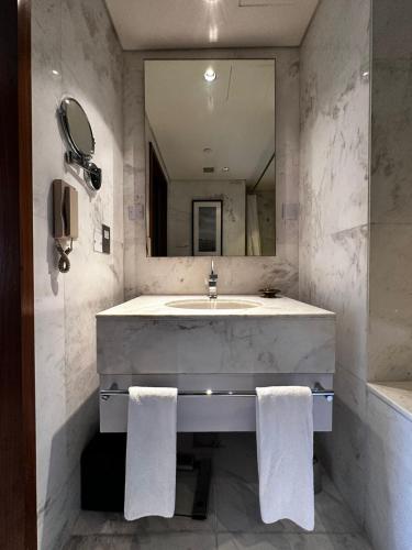 a bathroom with a sink and a mirror at Fashion Avenue Dubai Mall Burj Khalifa View Residence- Formerly Address Dubai Mall in Dubai