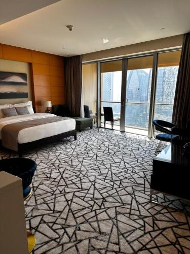 a hotel room with a bed and a large window at Fashion Avenue Dubai Mall Burj Khalifa View Residence- Formerly Address Dubai Mall in Dubai