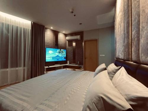 une chambre avec un grand lit et une télévision à écran plat dans l'établissement 2BedRoom-BestLocationBangkok-Emquartier-Metro-PhromPhong, à Bangkok