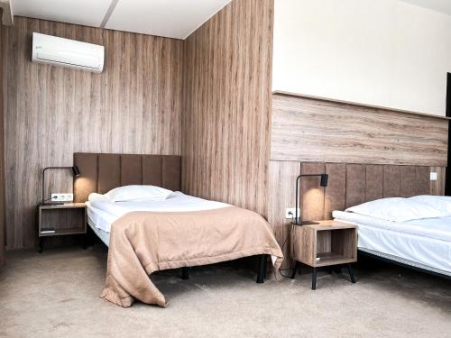 a hotel room with two beds and two tables at Aleanda in Chernivtsi