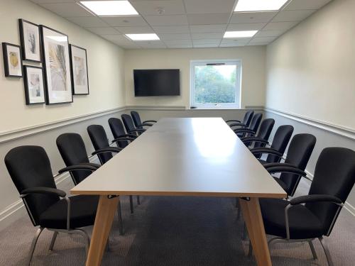 a conference room with a large table and chairs at Delta Hotels by Marriott Milton Keynes in Milton Keynes