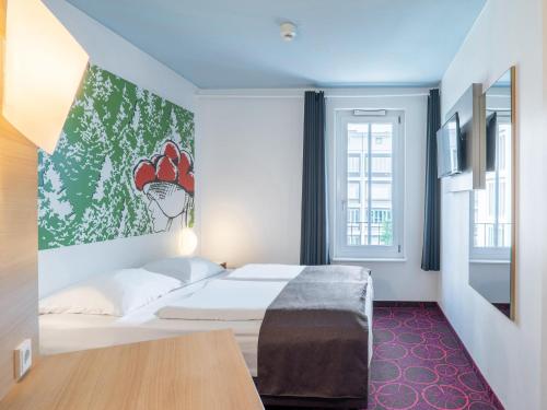 ein Hotelzimmer mit einem Bett und einem Fenster in der Unterkunft B&B Hotel Offenburg in Offenburg