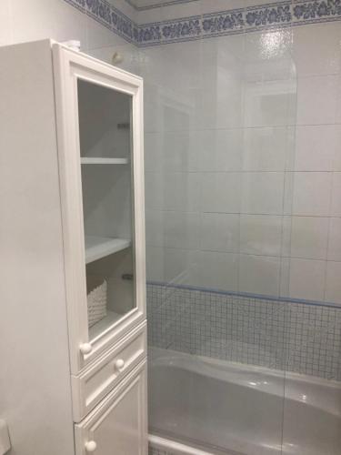 a bathroom with a white cabinet and a bath tub at Espacioso apartamento en Barbate con Wifi in Barbate