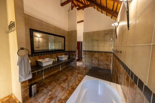 a large bathroom with two sinks and a tub at Eden Safari Country House in Marloth Park