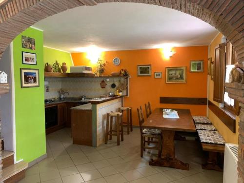 cocina con mesa y pared verde y naranja en La casetta al lavatoio, en Borgo a Mozzano