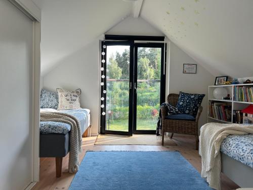 a attic room with two beds and a window at Stylish lake view house in Vadstena