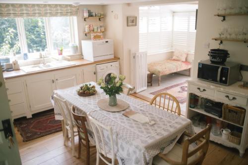 een keuken met een tafel met een witte tafeldoek bij Blossom Barn Harting in South Harting