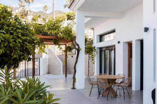 un patio con mesa, sillas y plantas en Luxury Top Villa Alhambra Pool close to Sea and Centre en Benalmádena