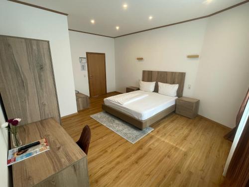 a bedroom with a bed and a wooden floor at Lothringer Hof in Saarlouis