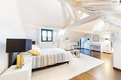 a white bedroom with a bed and a desk at L'hermine de Sologne in Courmemin