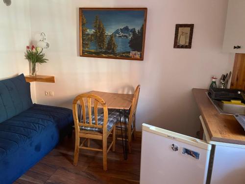 ein Wohnzimmer mit einem Tisch und einem blauen Sofa in der Unterkunft Chybotek. Domek in Preseka