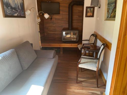 a living room with a couch and a wood stove at Chybotek. Domek in Przesieka