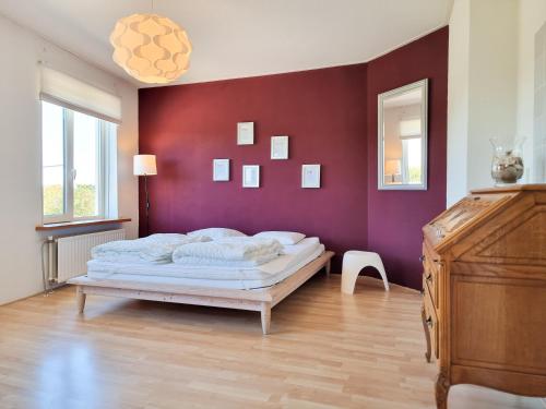 een slaapkamer met een bed en een paarse muur bij Ruim appartement Vlissingen VL23 in Vlissingen