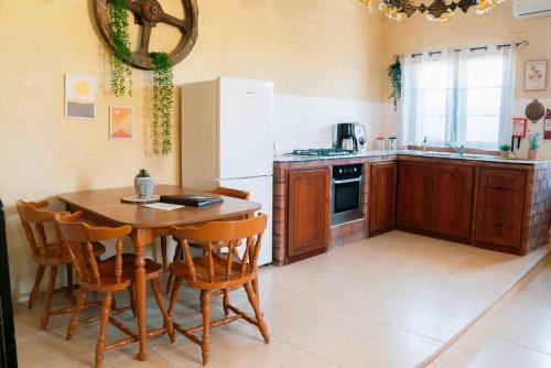 a kitchen with a table and chairs and a refrigerator at Kampanjola in San Lawrenz