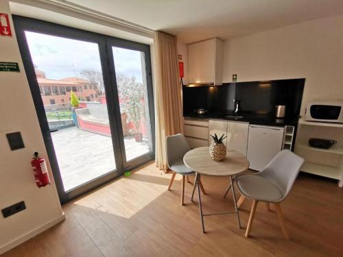 a kitchen with a table and chairs in a room at Chalé Esmeralda - Charming Studios in Calheta Beach in Calheta