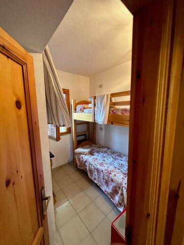 a small room with a bed and bunk beds at San Teodoro Appartamento Vacanze Centro in San Teodoro