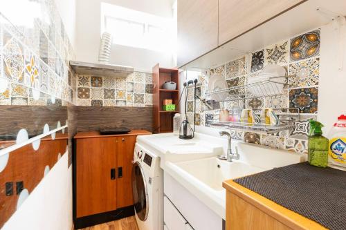a kitchen with a sink and a washing machine at Spacious Studio at citycentre in Singapore