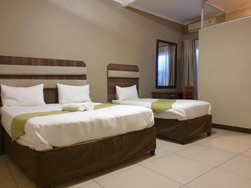 two beds sitting next to each other in a room at Cube Hotel in Durban