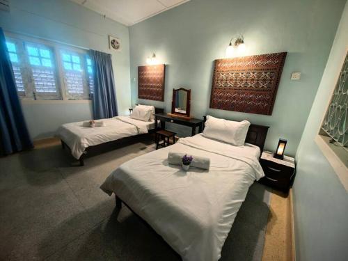 una habitación de hotel con 2 camas y una habitación con en LS Colonial Styled 4BR Bangalow, en Tanjung Bungah