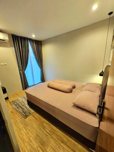 a bedroom with a large bed with a large window at Rania Guest House in Salakan