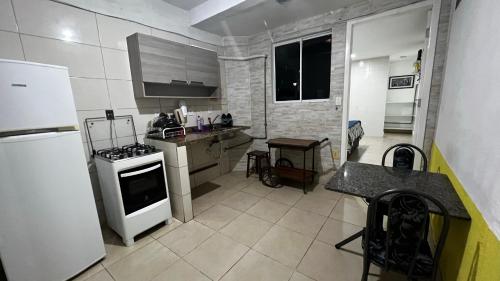 a kitchen with a stove and a white refrigerator at Best House Victoria in Vitória