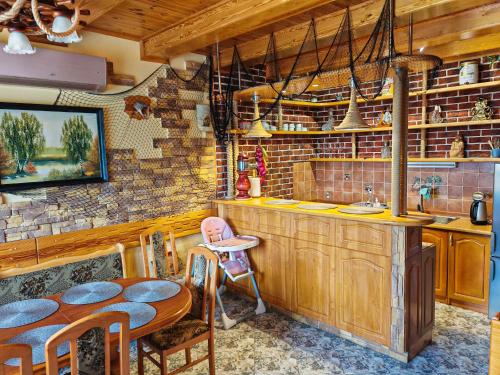 a kitchen with a table and chairs and a sink at Duży Domek Nad Jeziorem - Kretowiny 64 in Kretowiny