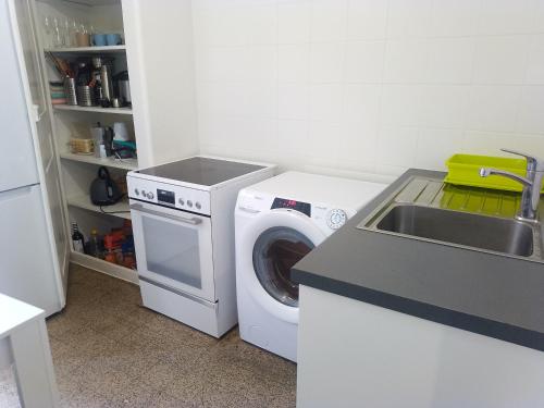 a kitchen with a washing machine and a sink at Charming flat center and near the lake in Geneva