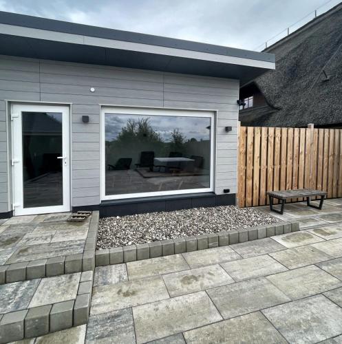 a patio with a bench in front of a house at Mare Balticum Urlaub auf Rügen in Sagard