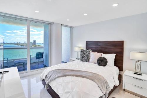 a bedroom with a large bed and a large window at Feels Like Summer ~ Panoramic Water Views! in Miami