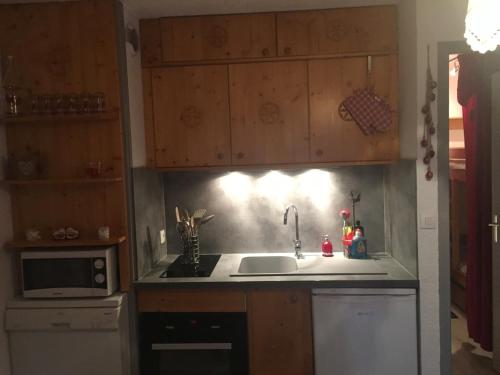 une cuisine avec un évier et un micro-ondes dans l'établissement Charmant Studio Cabine pour 3 à Valloire – Proche Commerces et Remontées Mécaniques - FR-1-263-68, à Valloire