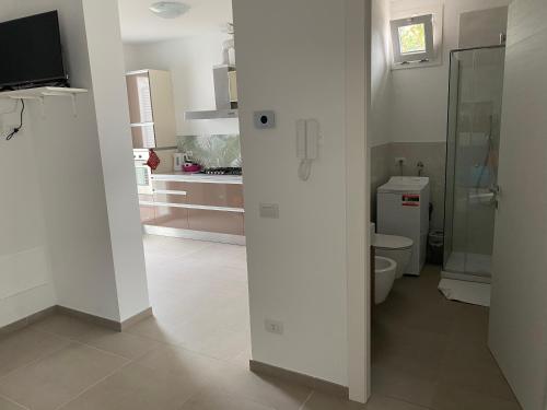 ein weißes Bad mit WC und eine Küche in der Unterkunft Villa Popilia Sea&Business Blue in Rimini
