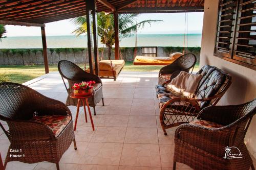 a patio with chairs and a table with a view of the ocean at Espaço Varanda e Mar in São Miguel do Gostoso