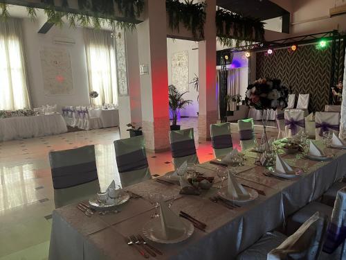 a long table in a room with tables and chairs at Casa Ardeleană in Ploieşti