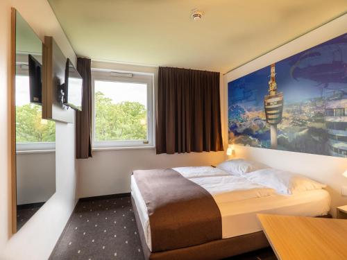 ein Hotelzimmer mit einem Bett und einem Fenster in der Unterkunft B&B Hotel Stuttgart-Airport/Messe in Stuttgart