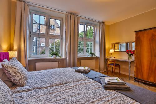 sypialnia z dużym łóżkiem z dwoma ręcznikami w obiekcie Apartament Bursztynowy Mariacka Old Town w Gdańsku