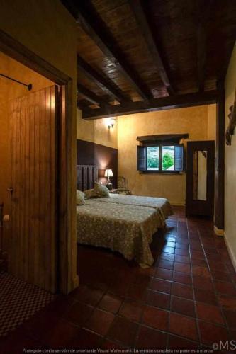 a bedroom with a bed and a window at CASA RURAL LA CORVA in Triollo