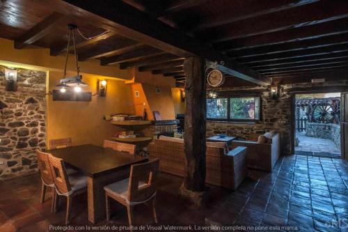 een keuken en een woonkamer met een tafel en stoelen bij Casa rural la corva in Triollo