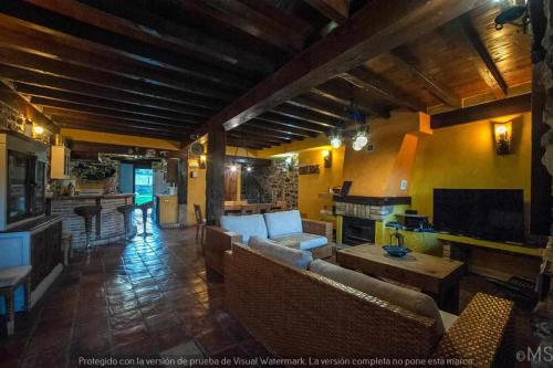 salon z kanapami i stołem oraz kuchnia w obiekcie Casa rural la corva w mieście Triollo