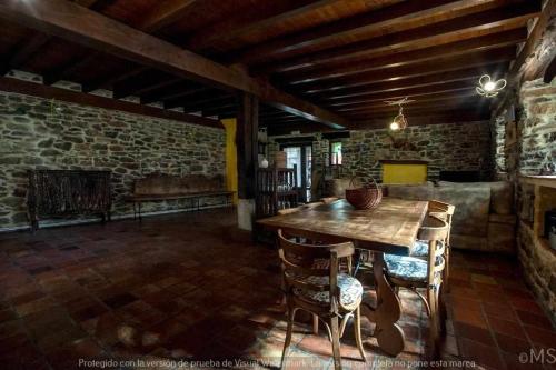 a dining room with a table and a fireplace at Casa rural la parda in Triollo