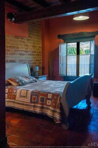 a bedroom with a bed and a brick wall at Casa rural la parda in Triollo