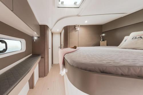 a large bed in a room with a window at Private Exclusive Catamaran 'Hang Loose' in Barcelona