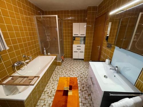 ein Badezimmer mit einer Badewanne, einem Waschbecken und einer Badewanne in der Unterkunft Ferienwohnung Penzkofer in Zandt